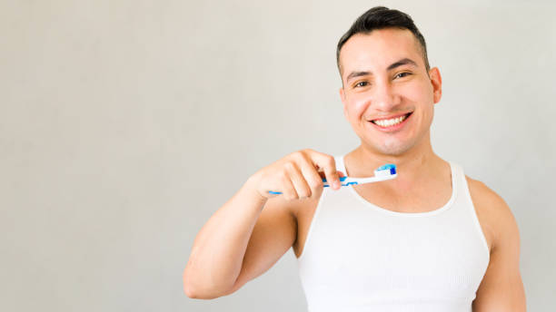 istock Man is happily brushing his teeth with toothpaste on his toothbrush in the morning 2170271081