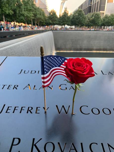New York City, Unites States of America - September 24, 2018: White rose laying on a name engraved in the bronze parapets of the North Pool of the 9/11 Memorial in New York City, commemorating the victims of the September 11 attacks