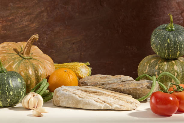 Photo frame with typical autumn fruits. Pumpkins, tomatoes, string beans, corn and garlic decorated with ice cubes on a vintage brown background. Front view, space for design