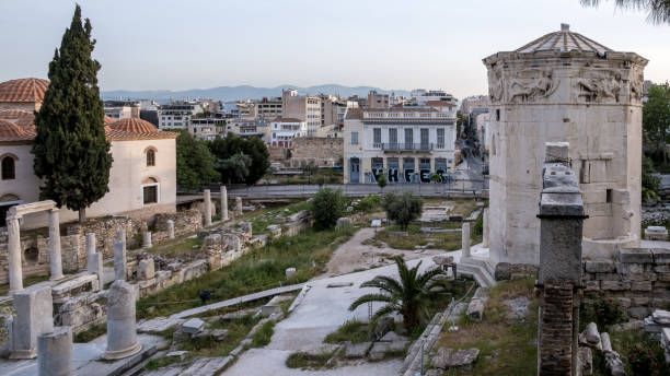 View of the Tower of the Winds, an octagonal clock tower in the Roman Agora of Athens, Greece View of the Tower of the Winds, an octagonal clock tower in the Roman Agora of Athens, made of Pentelic marble. Named for the eight large reliefs of wind gods on its top, it was originally topped by a wind vane and is the only surviving horologium from classical antiquity. Captured at sunrise in Athens' Old Town, the Roman Agora, highlights this historic site located north of the Acropolis and east of the Ancient Agora. nike air photos stock pictures, royalty-free photos & images