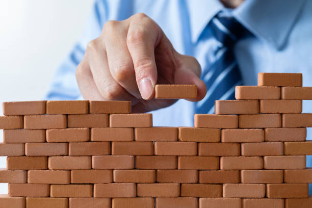istock Businessman putting toy brick onto a wall 2170275476