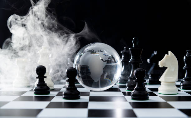 istock Glass earth globe and chess pieces with smoke 2170275556
