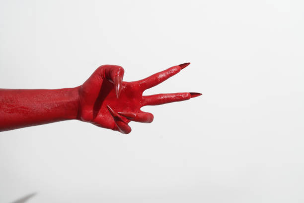 istock A witch's hand with long red nails on a white background, resembling a demon's or zombie's hand. This scary monster is perfect for Halloween, symbolizing a resurrected fictional creature. 2170278619