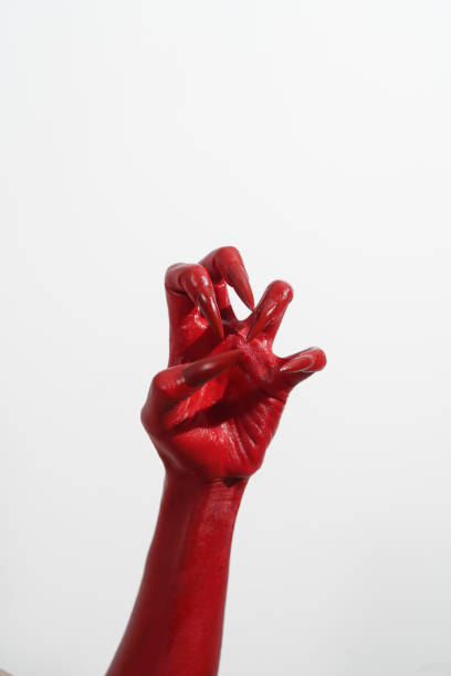 istock A witch's hand with long red nails on a white background, resembling a demon's or zombie's hand. This scary monster is perfect for Halloween, symbolizing a resurrected fictional creature. 2170278636