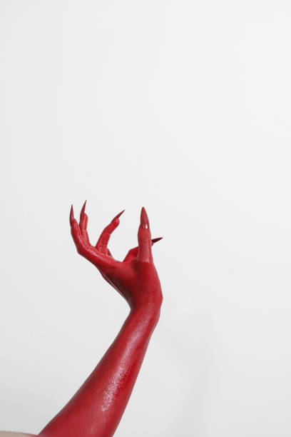 istock A witch's hand with long red nails on a white background, resembling a demon's or zombie's hand. This scary monster is perfect for Halloween, symbolizing a resurrected fictional creature. 2170278641