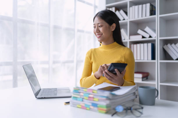 istock woman meticulously plans a finance audit, using a computer and calculator to review budget documents and ensure accuracy 2170280459