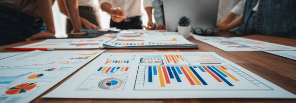 Focus financial report papers with blurred analyst team working. Scrutinize