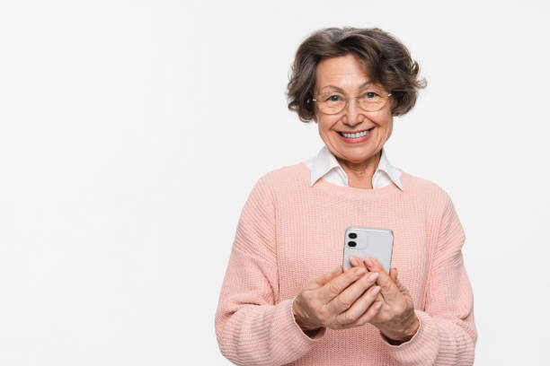 istock Smiling senior woman holding using mobile phone isolated. Technology concept 2170291513