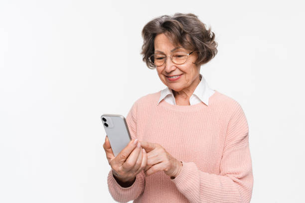 istock Senior woman holding smartphone using mobile phone browsing texting sms message chatting isolated 2170291527