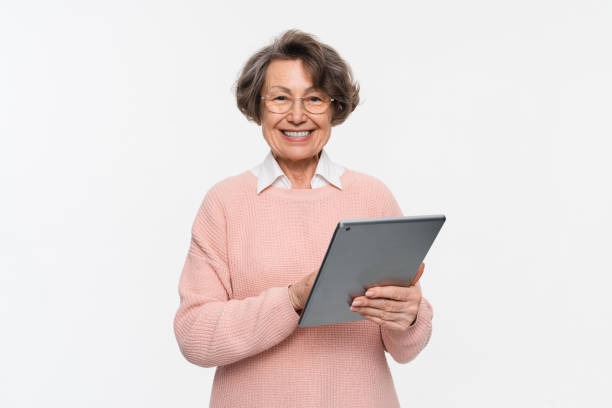 istock Happy old woman holding pad, working in tablet, doing online shopping, browsing internet isolated. 2170291587