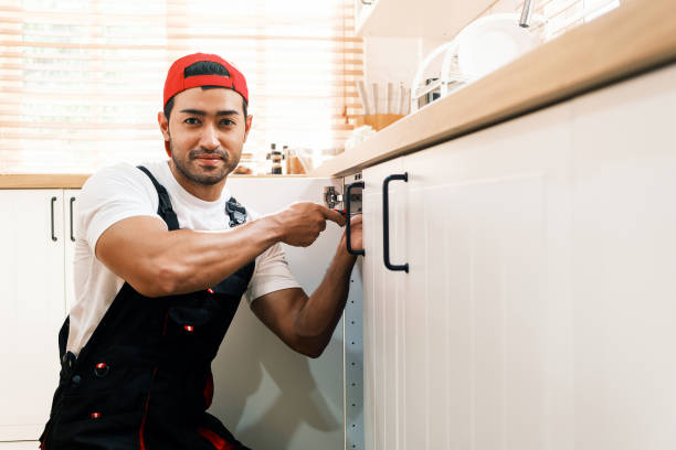istock Asian professional plumber man work in a uniform fixing a broken water pipe problem under the sink in the client kitchen house. Indoor sink leaky repairing service. Home improvement concept. 2170291666