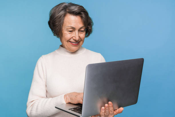 istock Mature woman using holding laptop pc computer, working online, communication with family. 2170291911