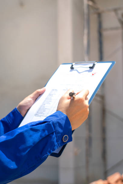 An architect is checking on house building quality checklist.