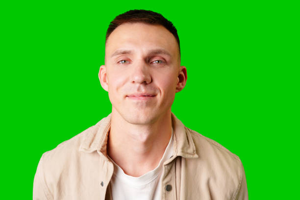 istock Young Man With Short Hair Smiling Against a Bright Green Background 2170292120