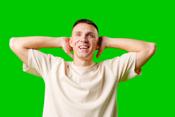 istock Man Reacting in Surprise With Hands on Head Against a Bright Green Background 2170292123
