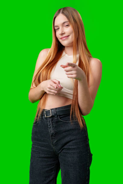 istock Smiling Young Woman Pointing at Camera With Green Screen Background 2170293959