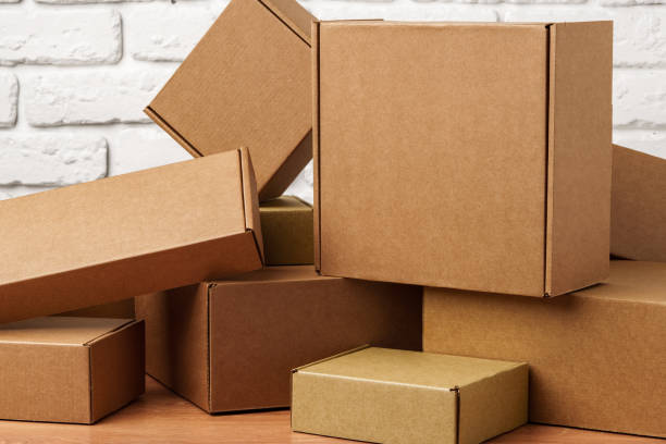 istock Stacked Cardboard Boxes Against A White Brick Wall 2170296258