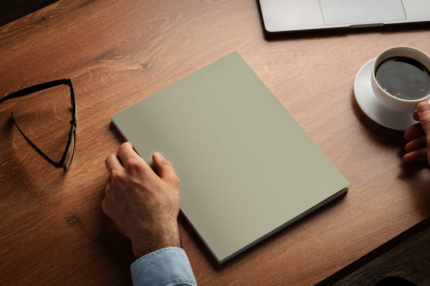 istock Man Reading Page of Magazine While Holding Coffee Cup 2170296270