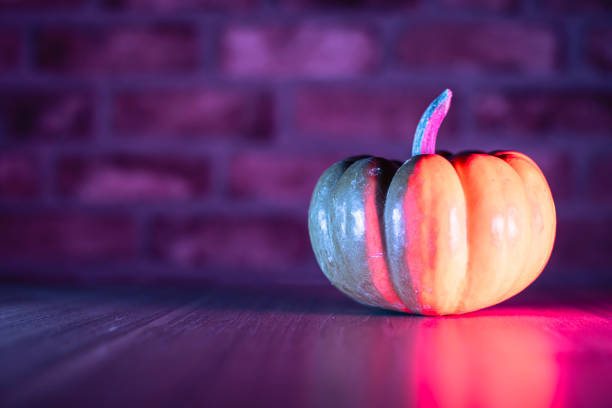 Pumpkin with neon lighting in dark, Halloween decoration