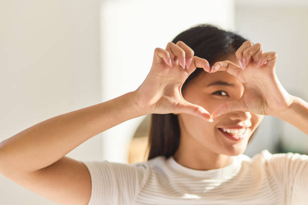 istock Eye Care. Woman Framing Eyes With Heart-Shaped Hands In Bright Light 2170297782