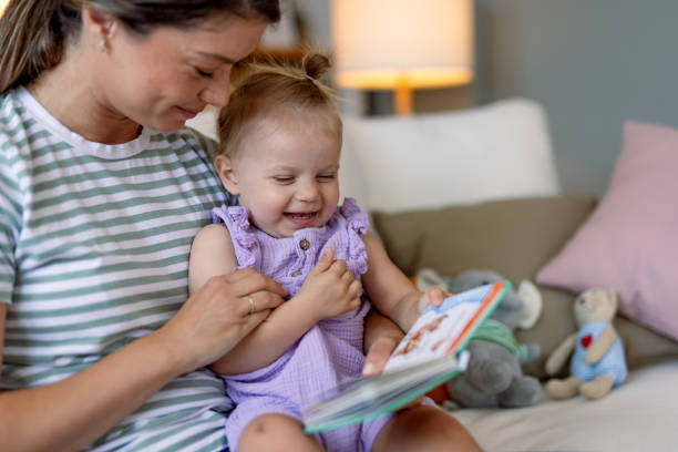 istock Mother and child smiling while reading on cozy sofa. 2170299861