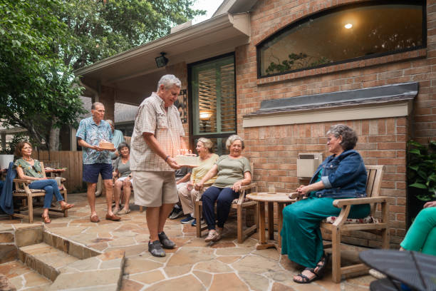 istock Cheerful senior group throws surprise birthday party with cakes in backyard 2170300423