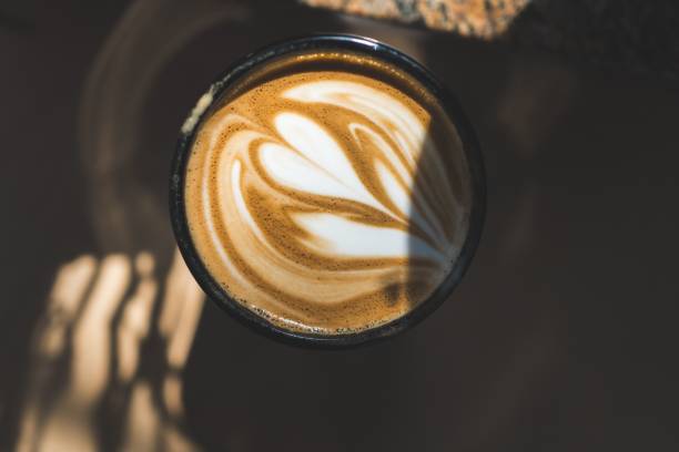 istock View of a beautiful cappuccino in a coffee cup with sunlight casting shadows on the table 2170300850