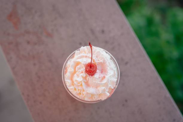 Cup of pink milkshake set on the stone