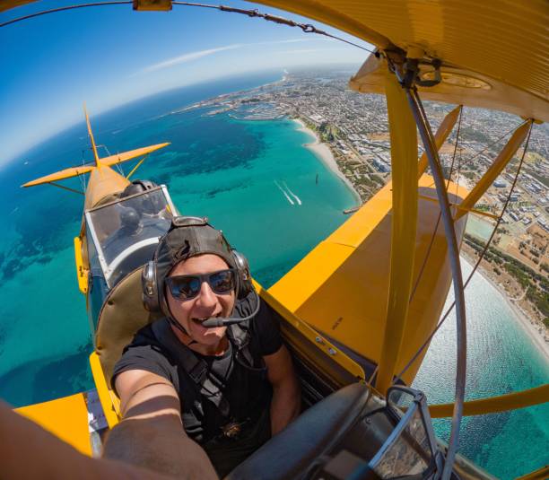 istock A man takes a selfie from aboard a yellow biplane. 2170301686