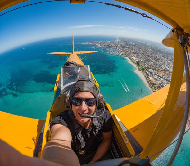 istock A man takes a selfie from aboard a yellow biplane. 2170301687