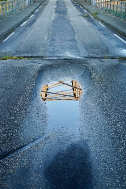 istock Of a bridge in a puddle on a deserted road. 2170304419