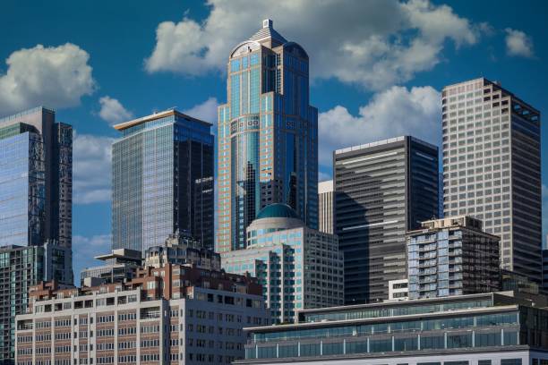 SEATTLE SKYLINE WITH SEVERAL OFFICE TOWERS AND A SKY WITH WHITE PUFFY CLOUDS  ON A LATE AFTERNOON FROM ELLIOTT BAY