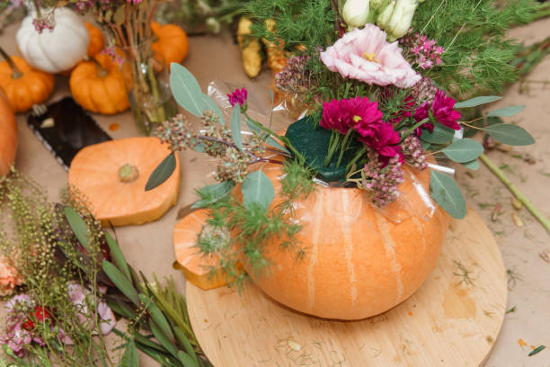 istock Flower arrangement in a pumpkin, autumn interior decor. Creating handmade autumn decor. 2170305084