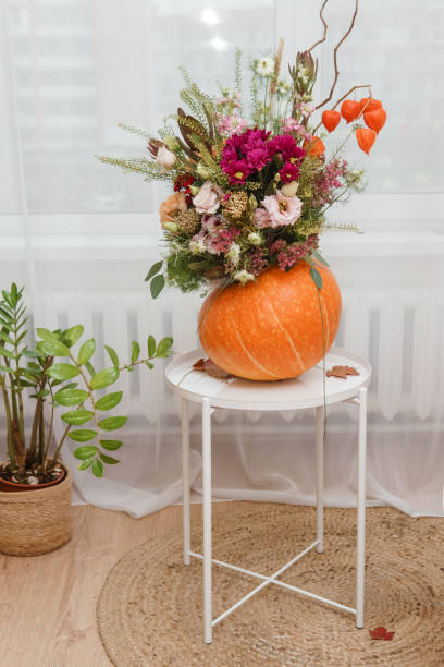 istock Flower arrangement in a pumpkin, autumn interior decor. Creating handmade autumn decor. 2170305432