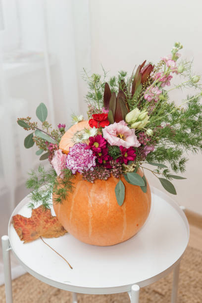 istock Flower arrangement in a pumpkin, autumn interior decor. Creating handmade autumn decor. 2170305437