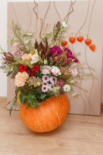 istock Flower arrangement in a pumpkin, autumn interior decor. Creating handmade autumn decor. 2170305443