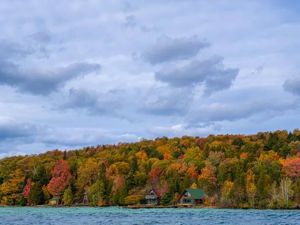 istock Autumn foliage and lakeside cabins under cloudy sky 2170306028