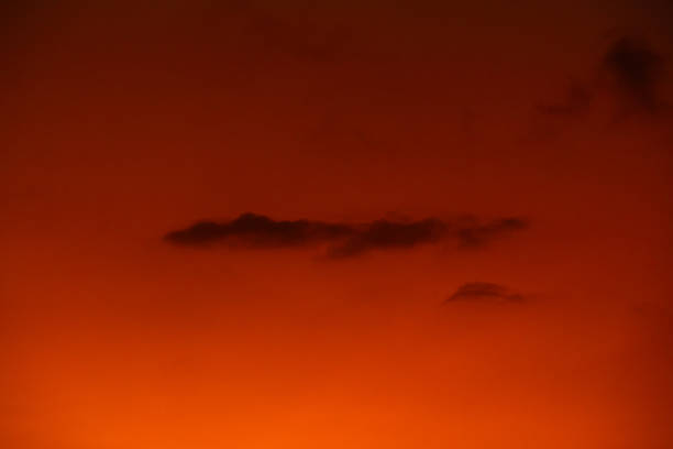 istock orange sky at dusk with cloud silhouettes 2170308439