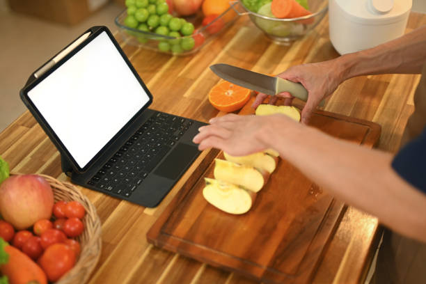 istock Man following an online recipe on digital tablet while making healthy meal in a kitchen 2170313552