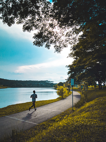 Foto de Homem Correndo Na Trilha Pelo Lago Contra O Céu e mais fotos de