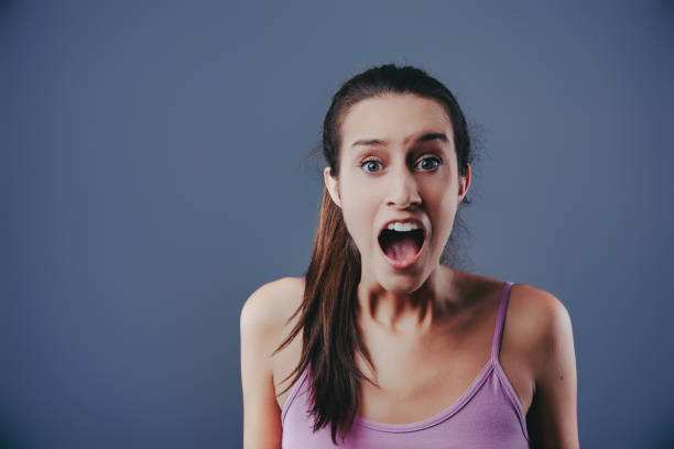 Woman Experiencing a Panic Attack while Sitting on a Sofa,Screaming in Desperation. Capturing the Intense Emotions of Anxiety,Fear,and Mental Health Struggles