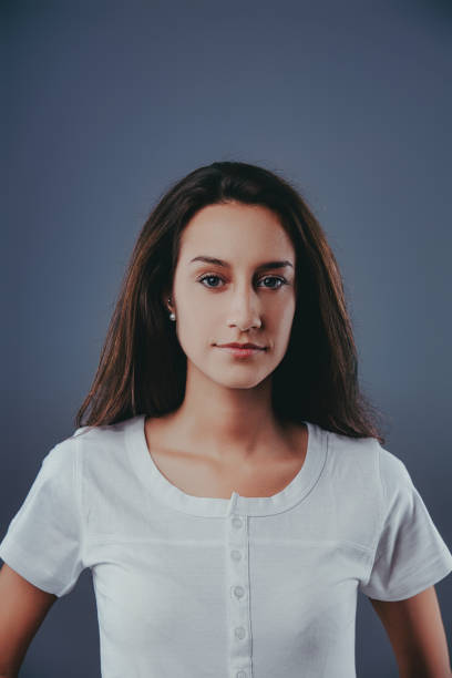 istock Young woman with long dark hair posing on a grey background 2170318240