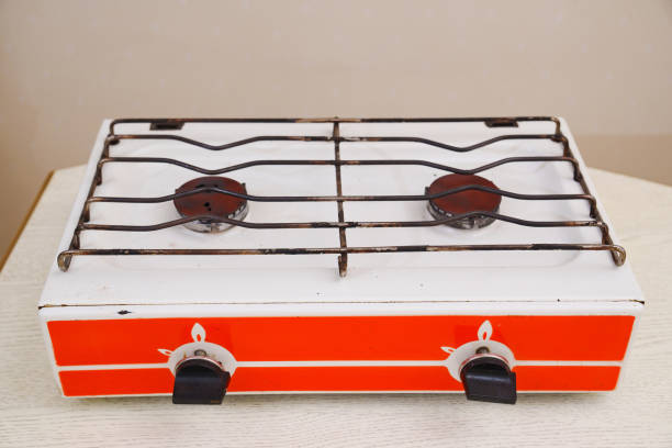 A close-up view of a gas stove burner actively producing blue flames, creating an image of controlled heat and power in a kitchen setting.