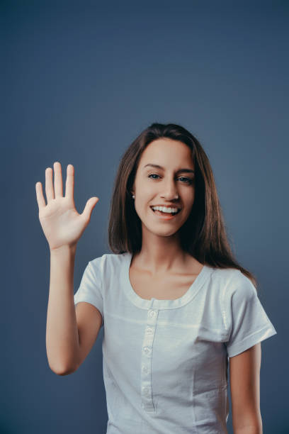 istock Young woman waving and smiling on blue background 2170325605