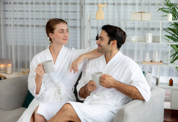 istock Couple wearing bathrobe relaxing with drinks in luxurious hotel spa. Quiescent 2170327947