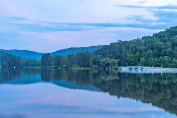 istock Setting sun low light long exposure over mountain lake summer season background image 2170329351