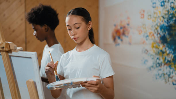 istock Multicultural student paint the canvas together in art lesson. Edification. 2170335472