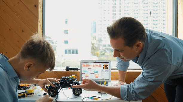 istock Teacher help student fixing car model and giving advise at class. Edification. 2170335781