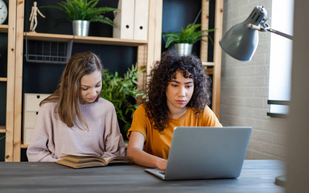 istock Happy multiethnic teenagers holding technology gadgets using digital devices studying together. 2170335928