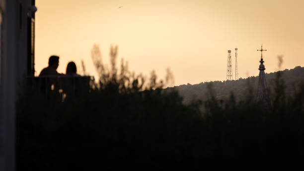 Couple is watching the sunset on the balcony. Jelsa - Hvar Island.